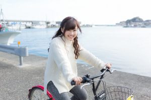 漁港付近で自転車を乗る女性