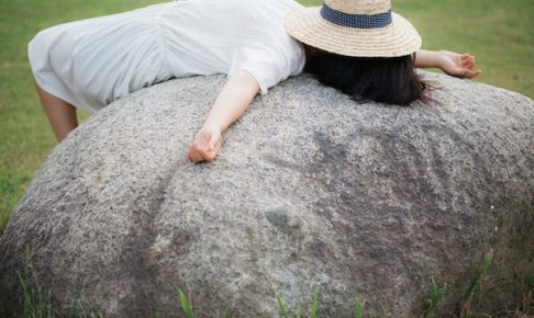 石の上で寝ている女性