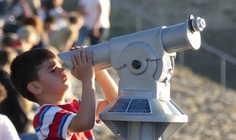 望遠鏡を覗いている少年